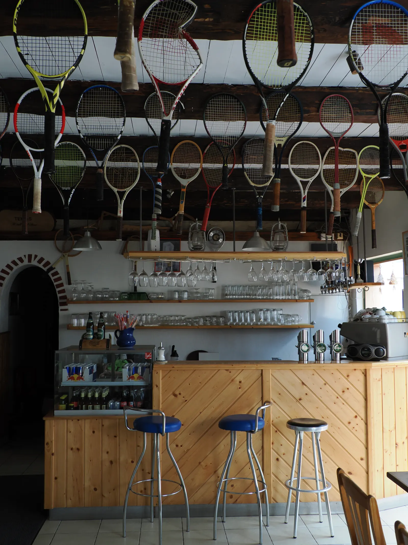 Bar im Tennisstüberl unter einer Sammlung alter Tennisschläger